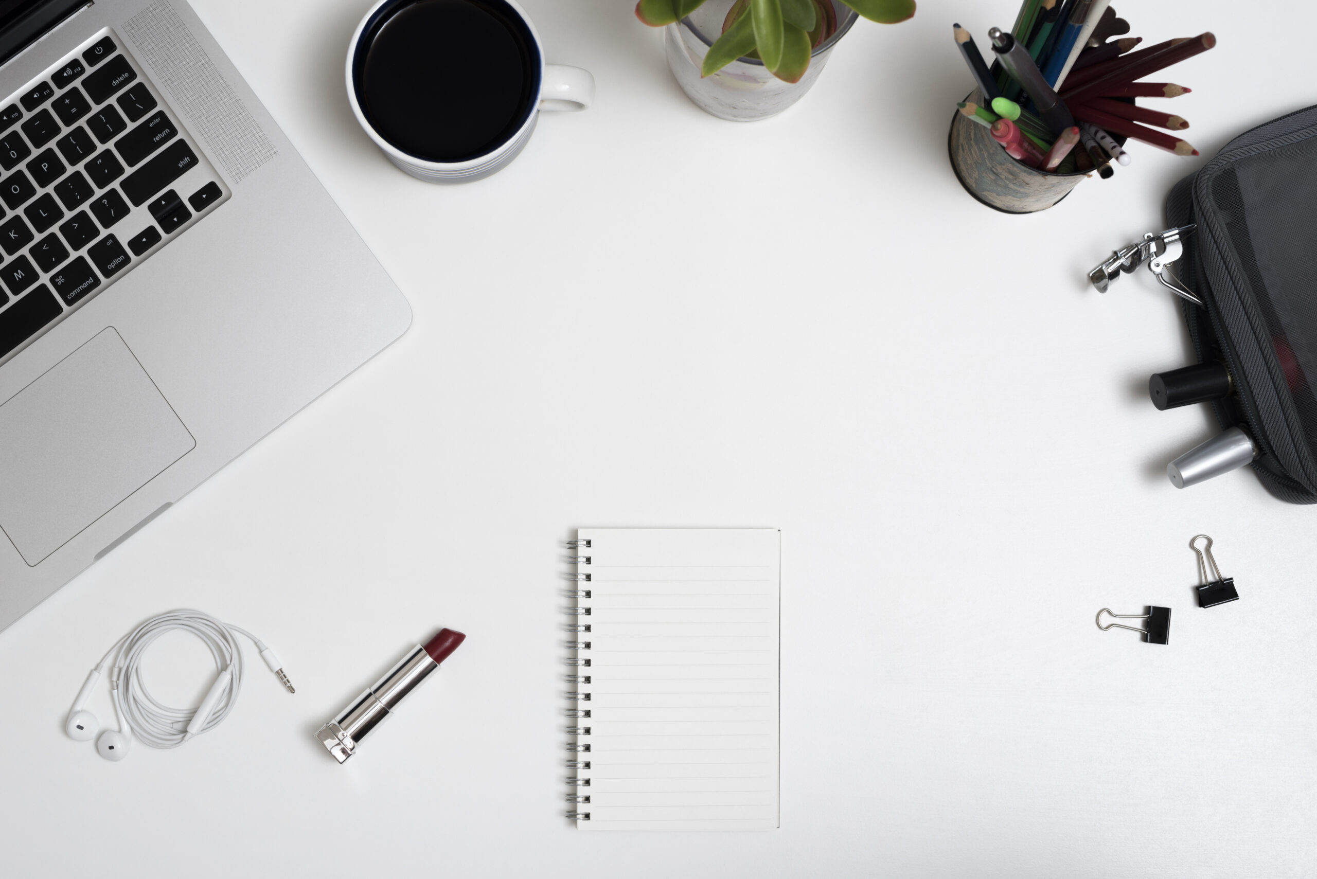 high-angle-view-laptop-coffee-cup-makeup-pouch-pencils-office-desk